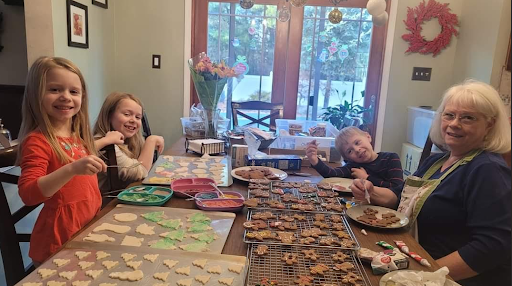 Katherine Devillasanta’s daughters decorating cookies with their grandmother.